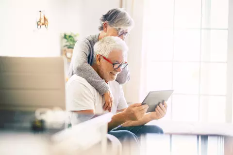 Une femme et un homme âgés regardent l’écran d’un iPad
