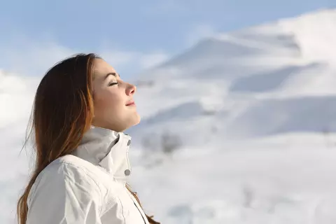 Frau atmet Winterlandschaft