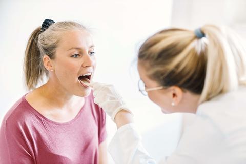 Ärztin schaut Patientin in den Mund 